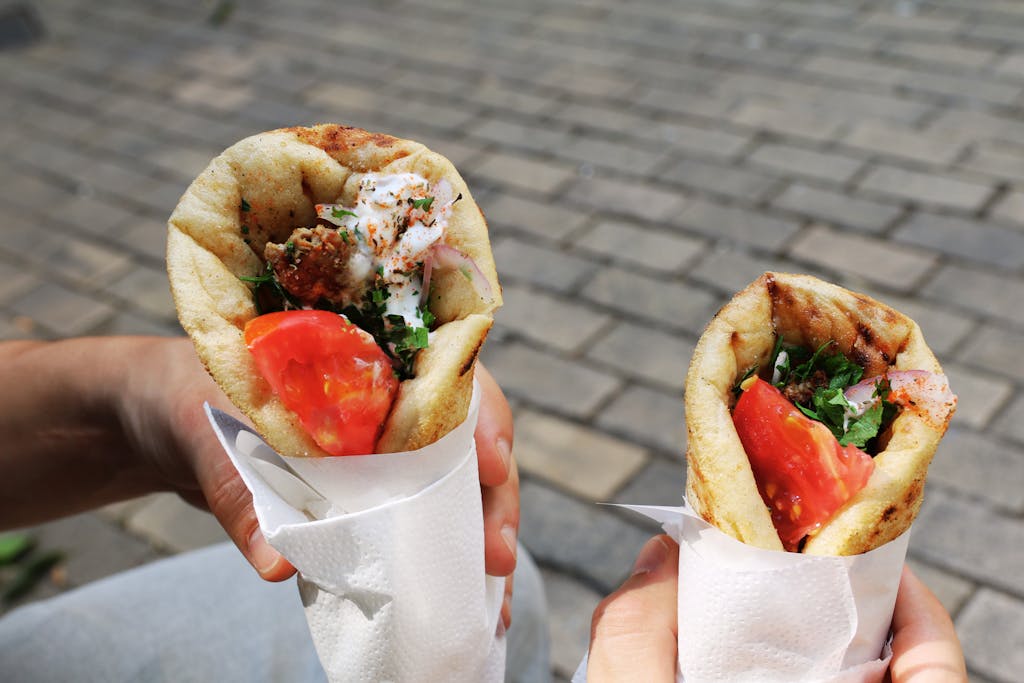 Two fresh gyros with tomato and herbs, perfect Greek street food for a sunny day.